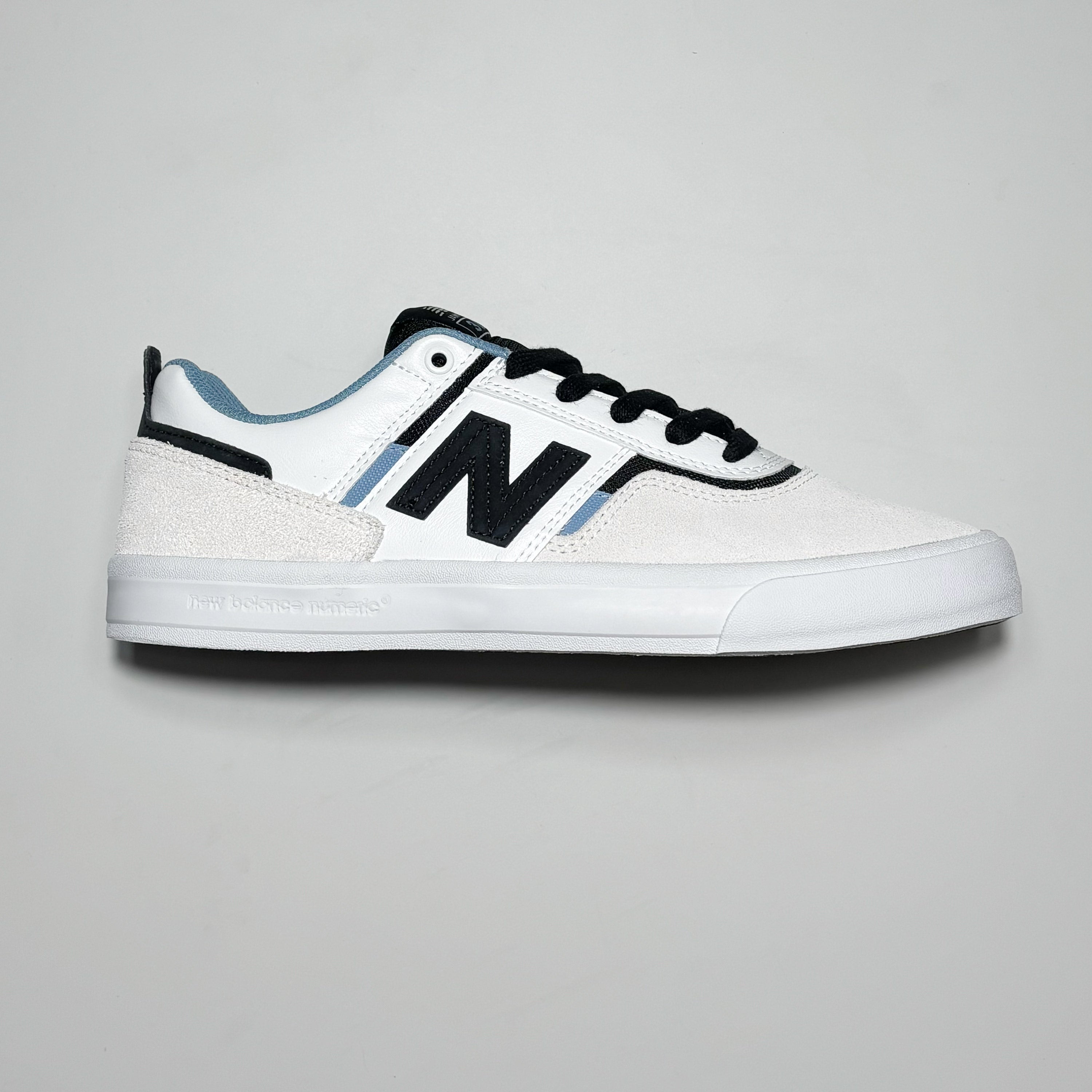 Side image of right shoe.
White suede with black N branding.