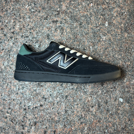 Side profile of right shoe. All black with white "N" and laces.