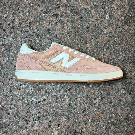 Side profile of right shoe. Light pink suede with white outsole and "N" branding.