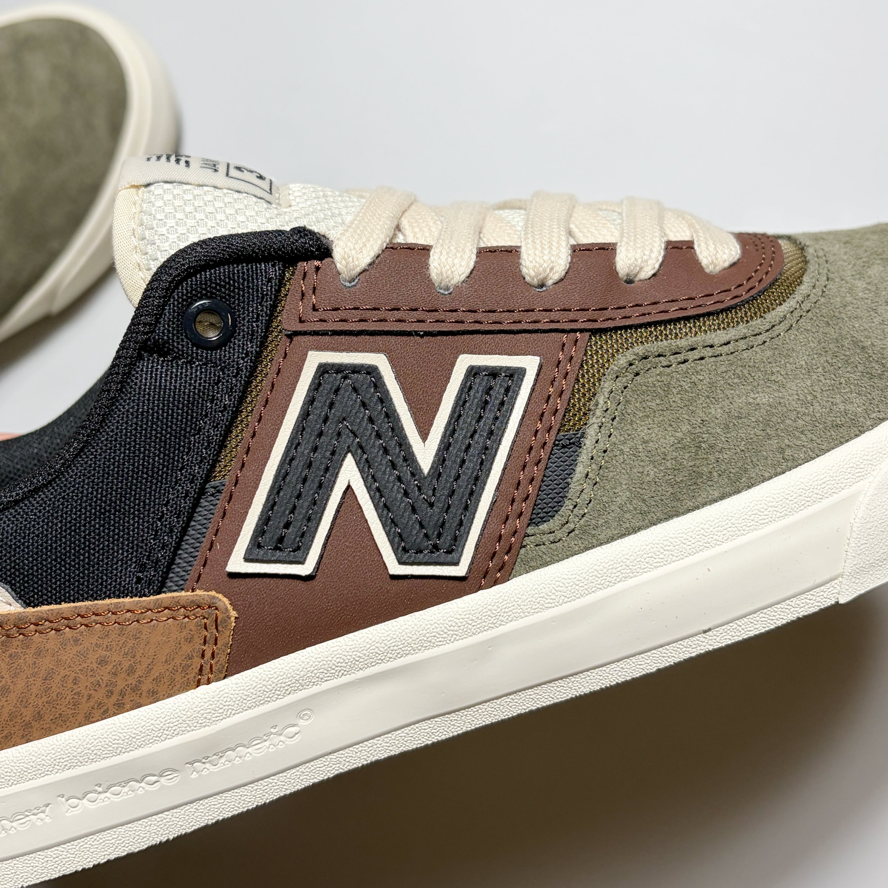 Close detail of "N"branding in black on brown mid-panel.