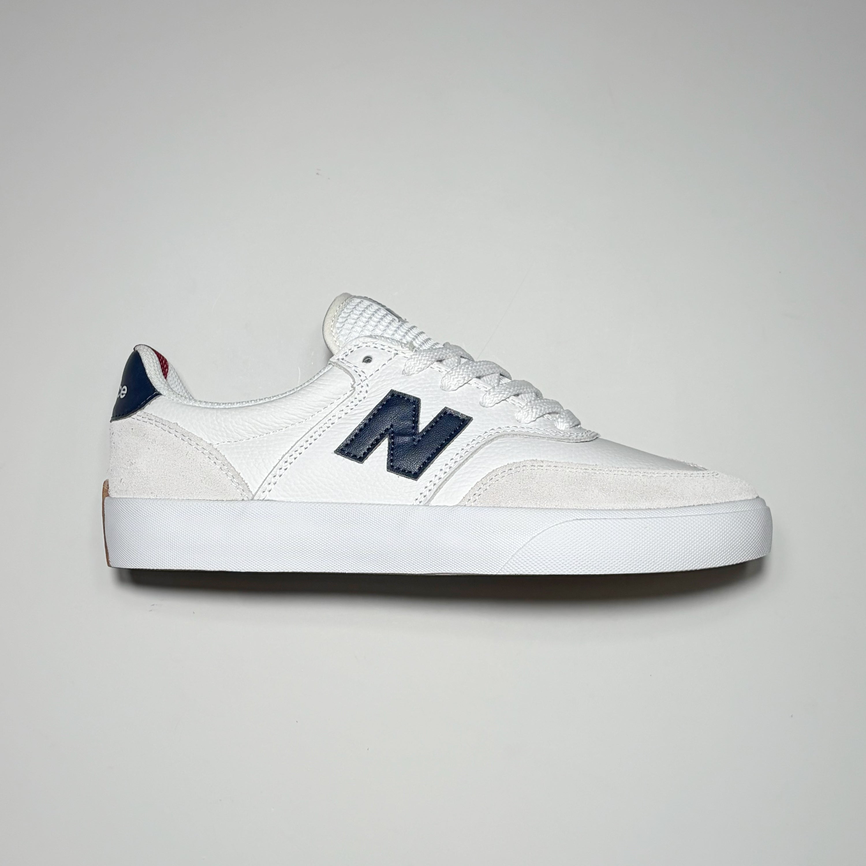 Right side image, white Numeric 340 shoe with navy "N" on mid-panel. 