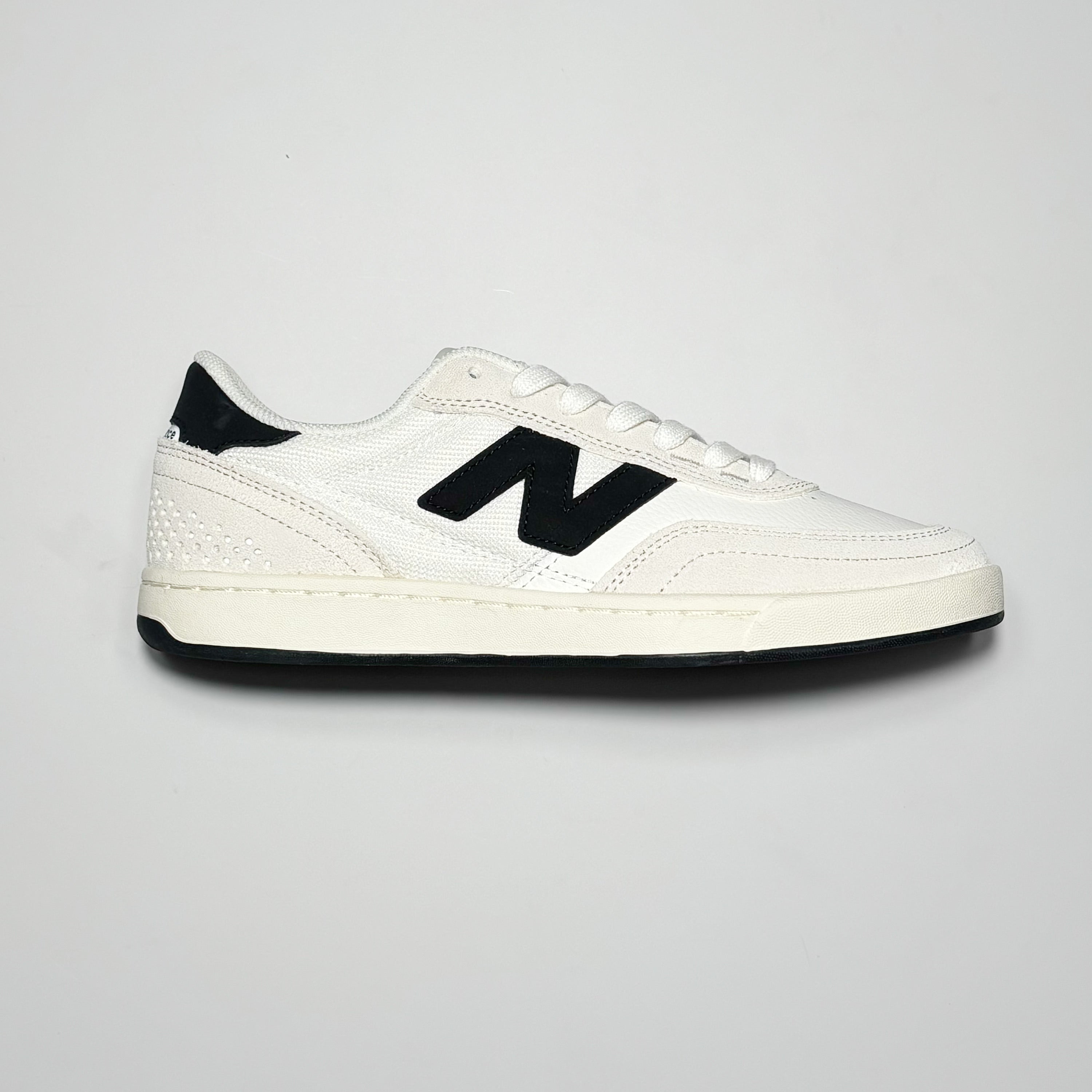Side image of right shoe. 
White suede with midsole and black N branding on mid panel