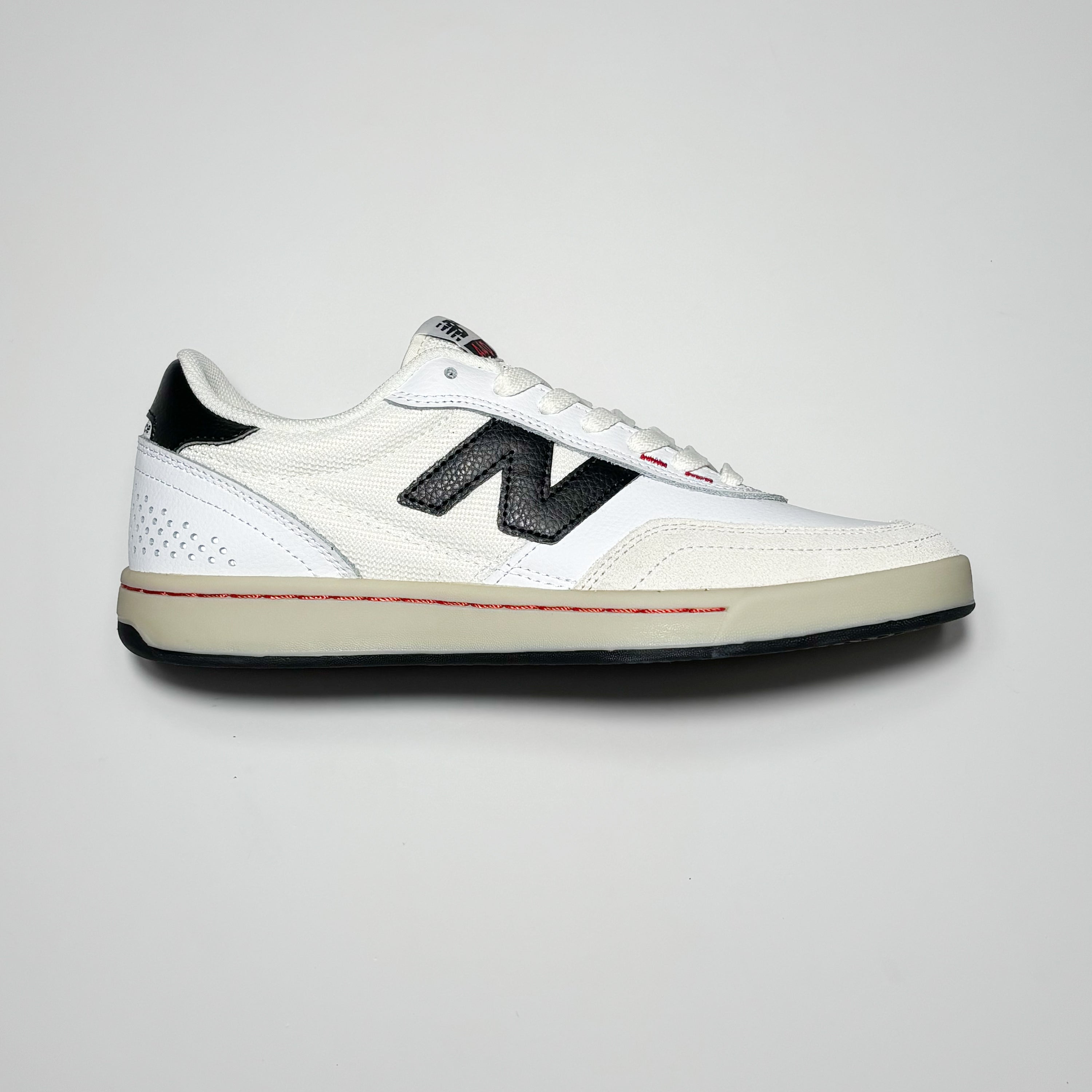 Side image of right shoe. White suede and leather with off white outsole.