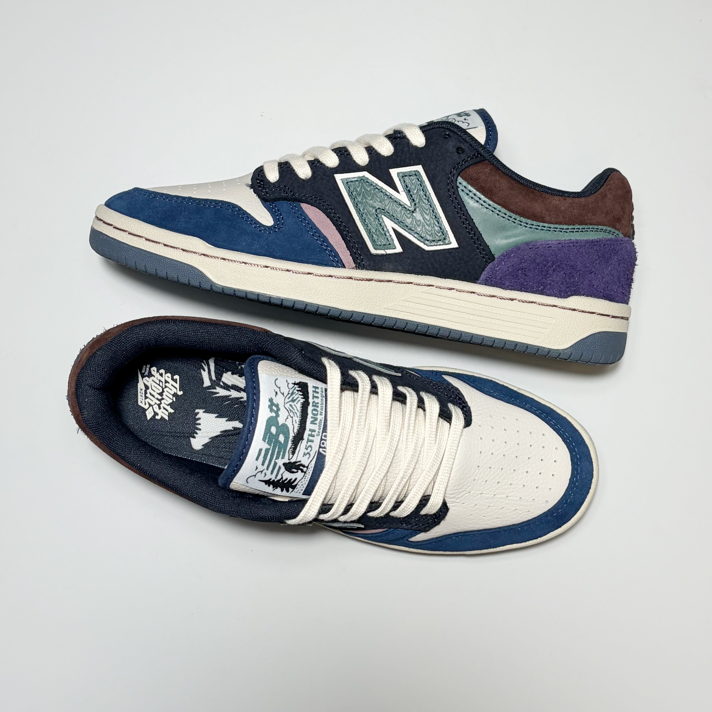 A pair of New Balance Numeric 480 sneakers in a multi-color colorway featuring navy blue suede, white leather, purple suede, teal suede, brown suede, and a cream midsole, displayed on a light gray background.
