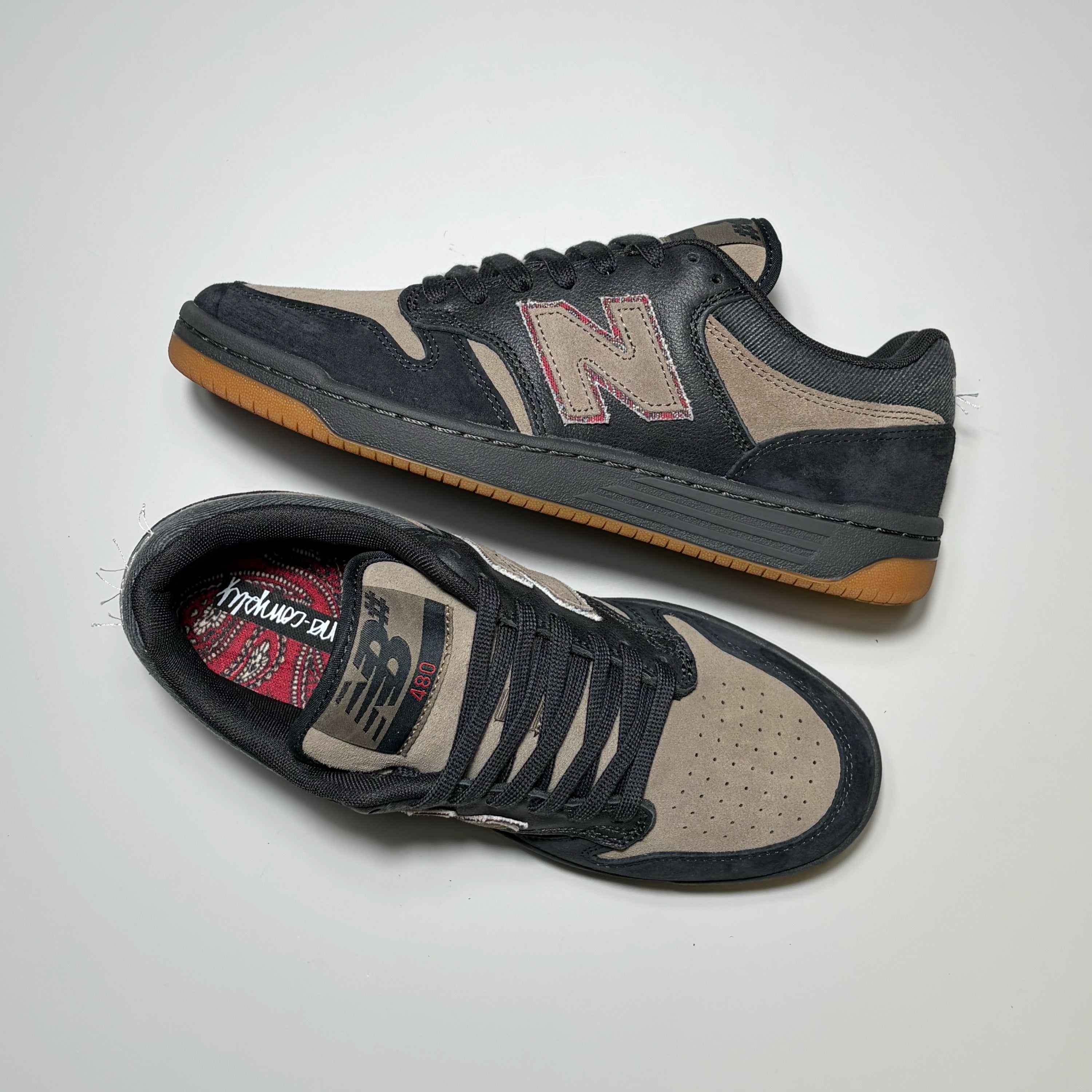 Pair of black and tan New Balance Numeric shoes with black laces.