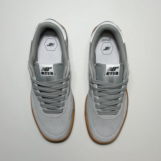 A pair of New Balance Numeric 440 V2 sneakers in gray suede and mesh, featuring brown gum soles, photographed from a top-down view on a light gray background.