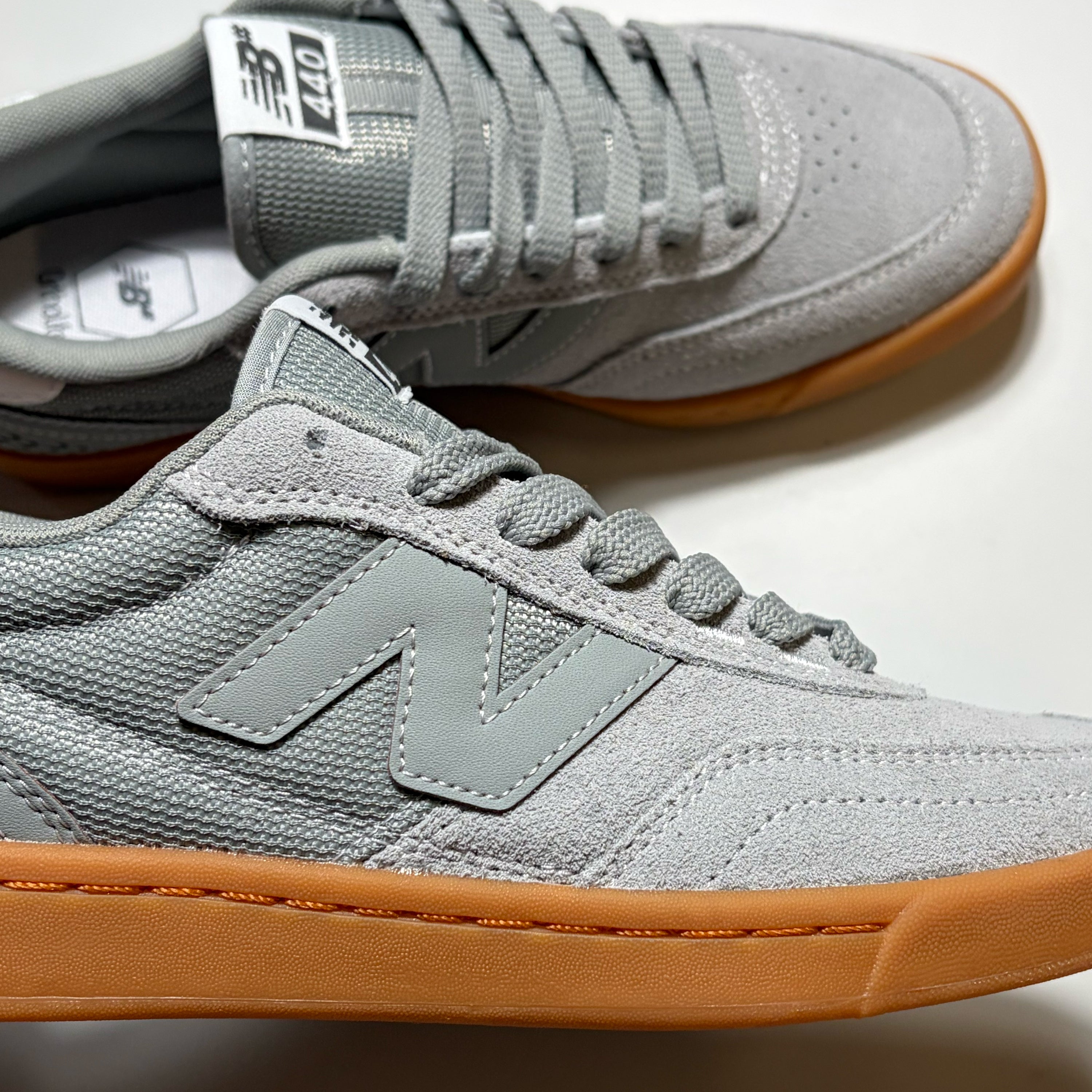 A pair of New Balance Numeric 440 skate shoes in light gray suede and mesh with a gum brown sole, shown on a clean white background.