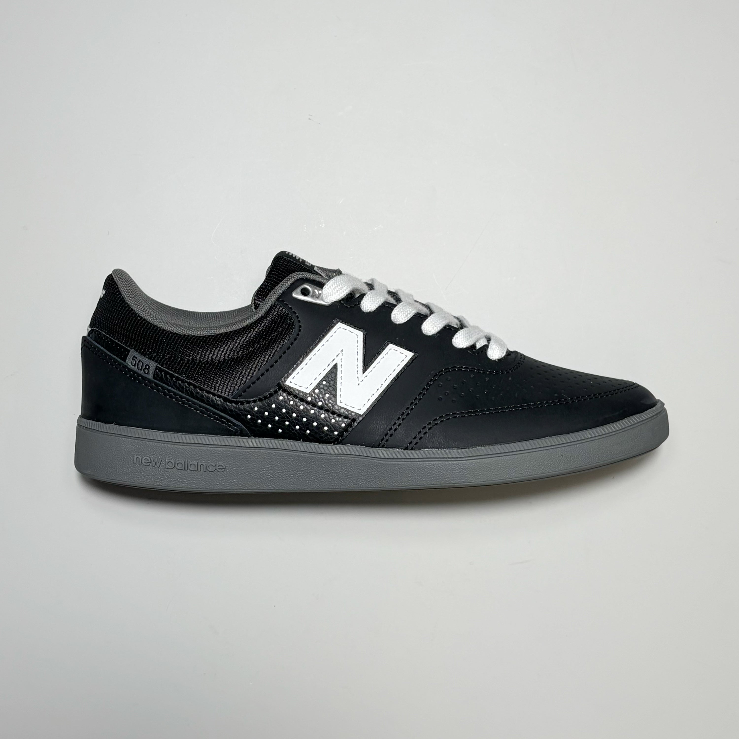 Right side image, New Balance Numeric NM508 shoes. Black nubuck with grey outsole and 'N' branding in white.