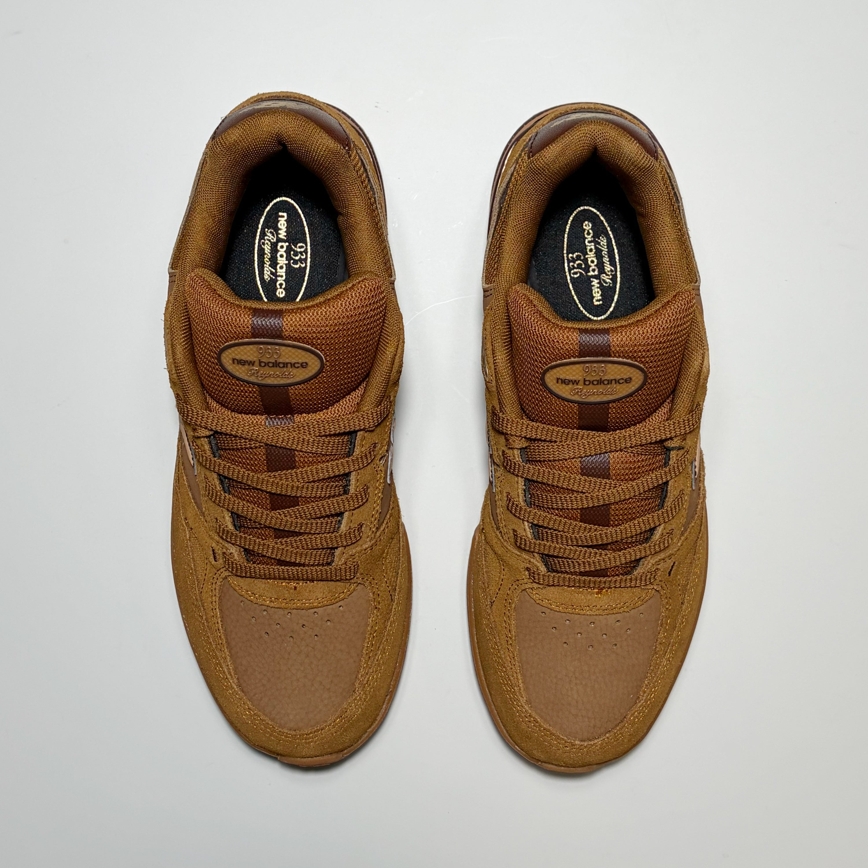 A pair of New Balance Numeric 933 sneakers in a monochromatic brown colorway, photographed from a top-down perspective on a light gray background.