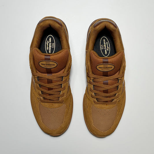 A pair of New Balance Numeric 933 sneakers in a monochromatic brown colorway, photographed from a top-down perspective on a light gray background.