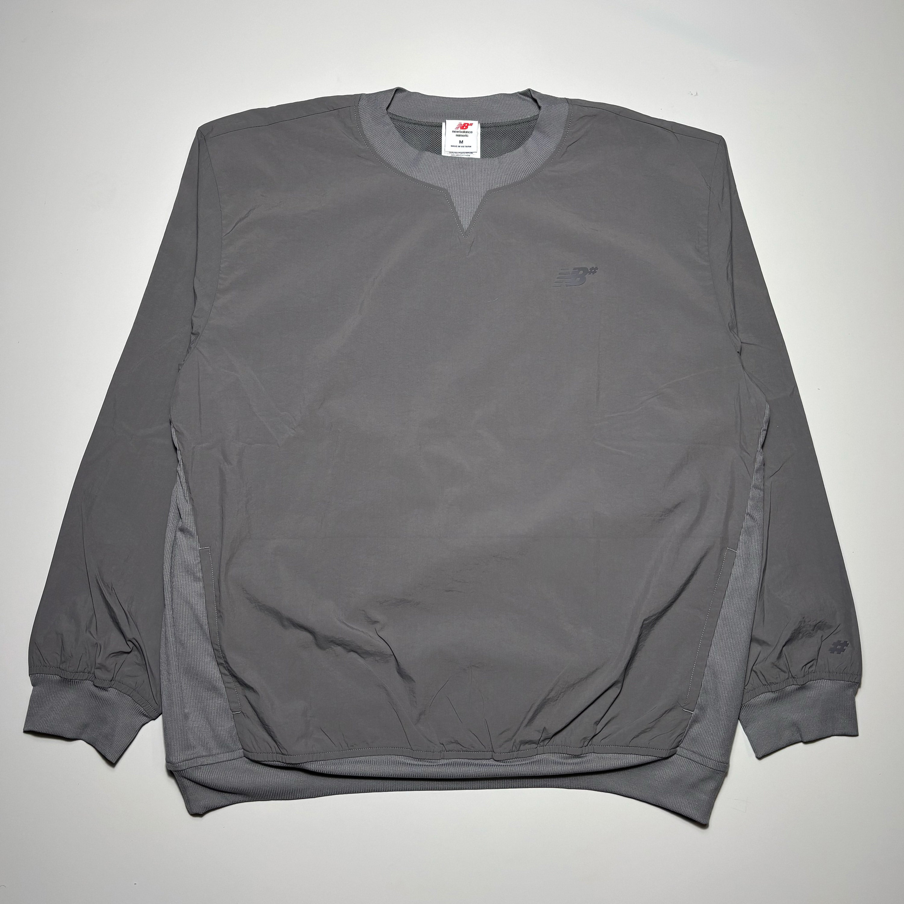 Full image of grey nylon crewneck. Tonal NB logo on chest.