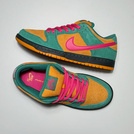A pair of Nike SB Dunk Low sneakers in a green, orange, and pink colorway, displayed on a light gray background.