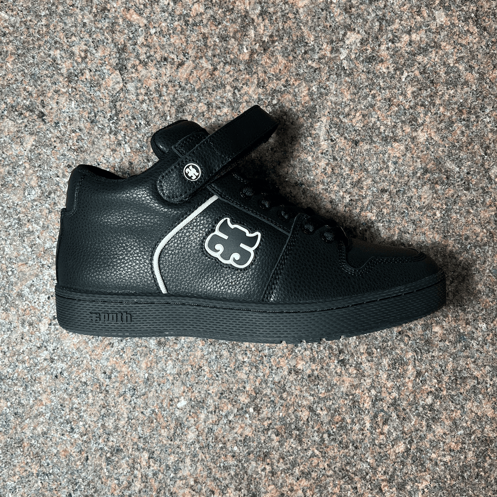 SIDE VIEW OF THE IPATH GRASSHOPPER IN BLACK LEATHER WITH WHITE OUTLINED IPATH LOGO AND BLACK SOLE