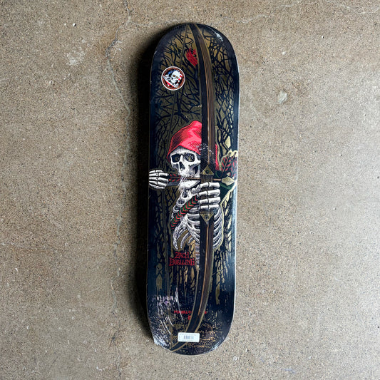 A Powell Flight Zach Doelling deck featuring a detailed graphic of a skeleton wearing a red hat, holding a bow and arrow, set against a dark forest background. The deck is photographed flat on a textured concrete floor