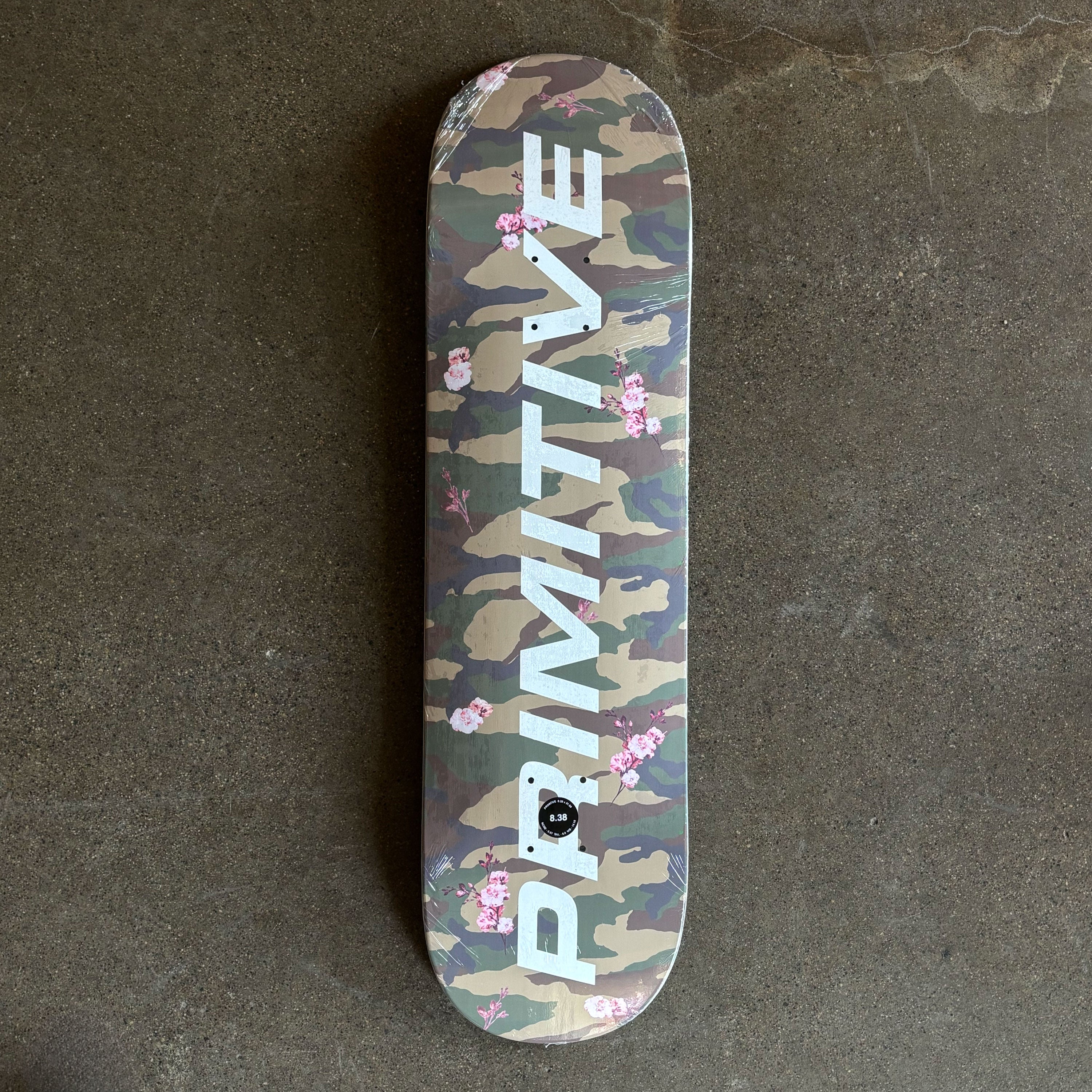 Full image of camo with cherry blossom flowers throughout deck and primitive font in white.