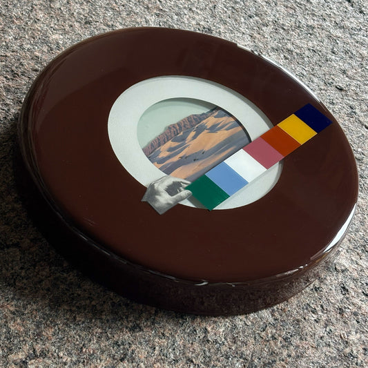Close detail of collage artwork. 
Encased in custom epoxy resin circle frame.