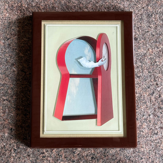 Framed artwork of a red keyhole with a blue sky and white bird inside, on a textured surface.