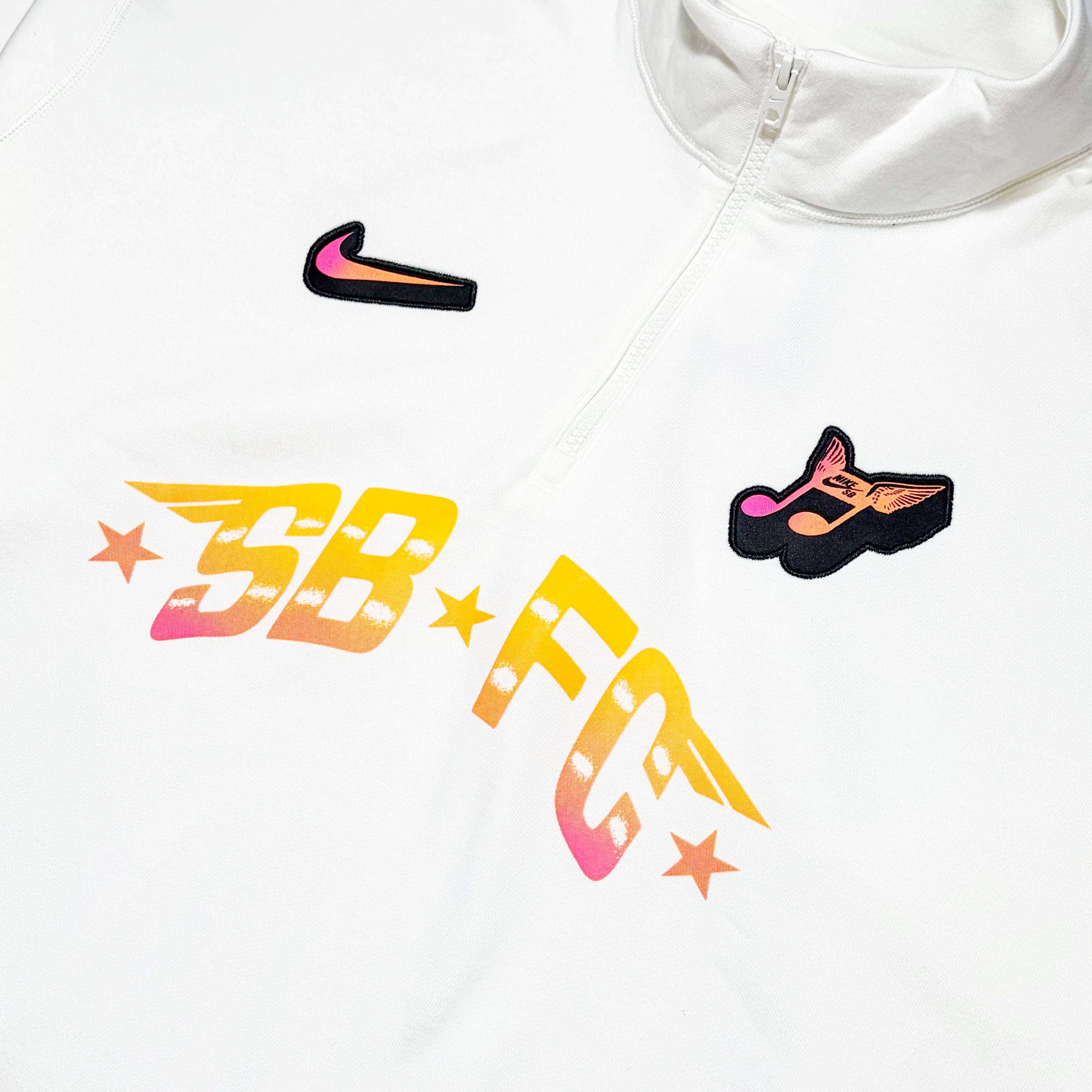 Close detail of Nike crewneck 
SB FC text in yellow gradient color with embroidered music note and swoosh above. 