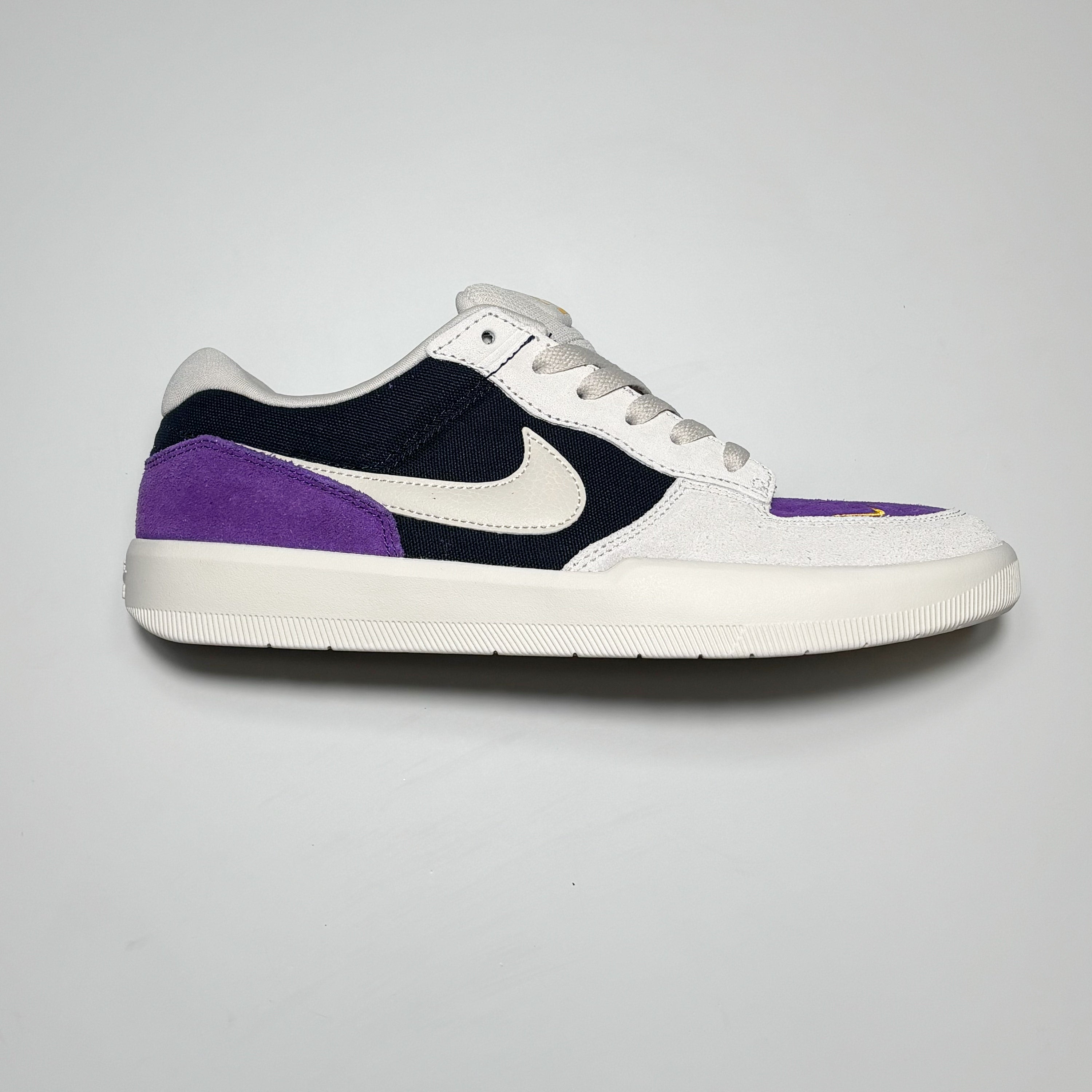 Side image of right shoe.
White suede with purple heel tab and toe box.