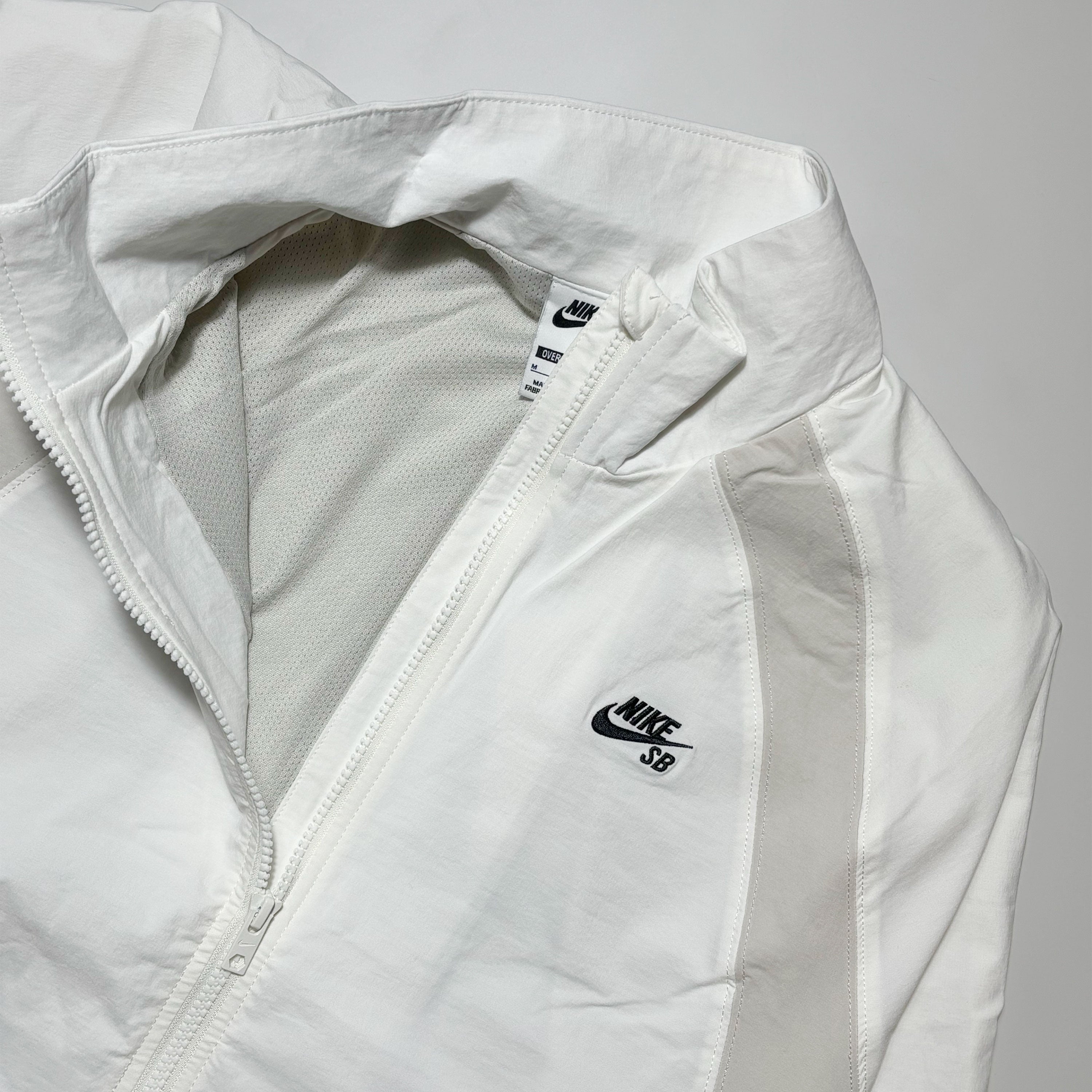 Close detail of embroidery on chest. Mesh lined woven jacket.