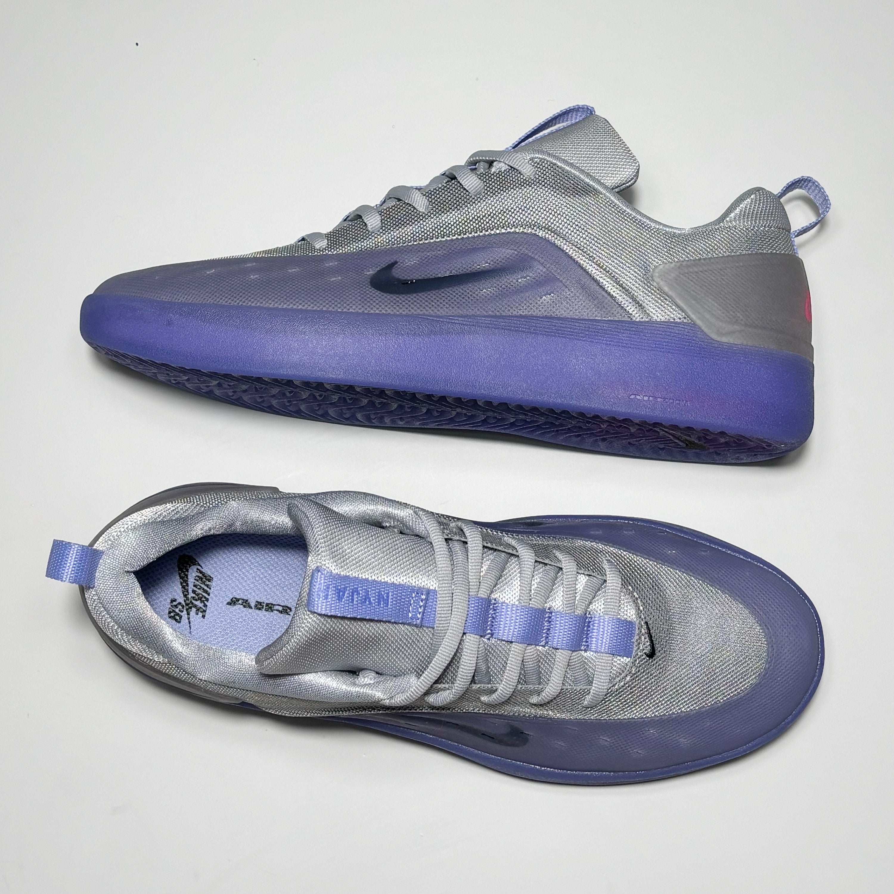 Gray and purple sneakers with Nike logo on a white background