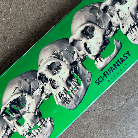 Close detail of skulls on green background. Sci-fi fantasy, ryan lay font in black.