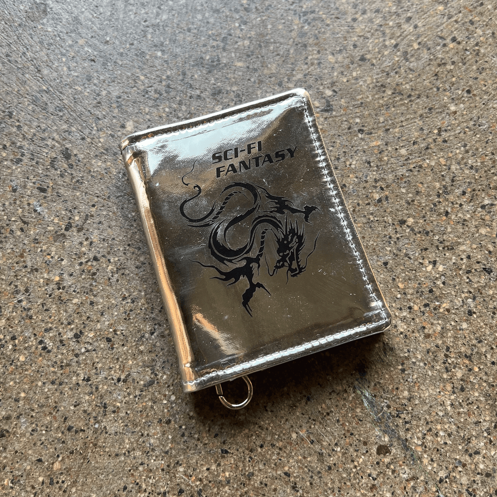 SILVER REFLECTIVE PATENT LEATHER WITH SNAP CLOSURE AND KEYCHAIN CLASP WITH BLACK PRINTED SCI-FI FANTASY LOGO AND DRAGON ART