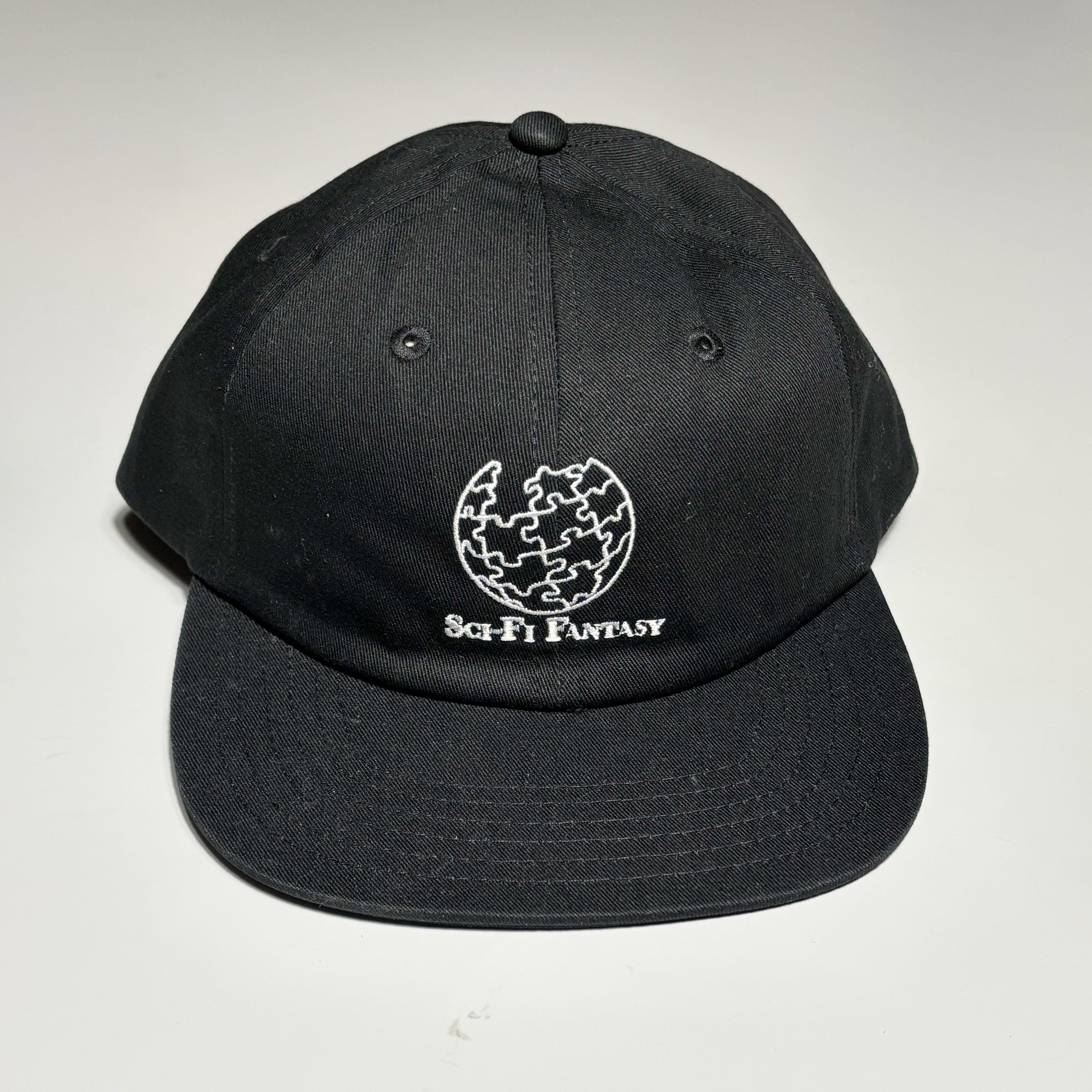 Front image of black hat with embroidered art on crown.