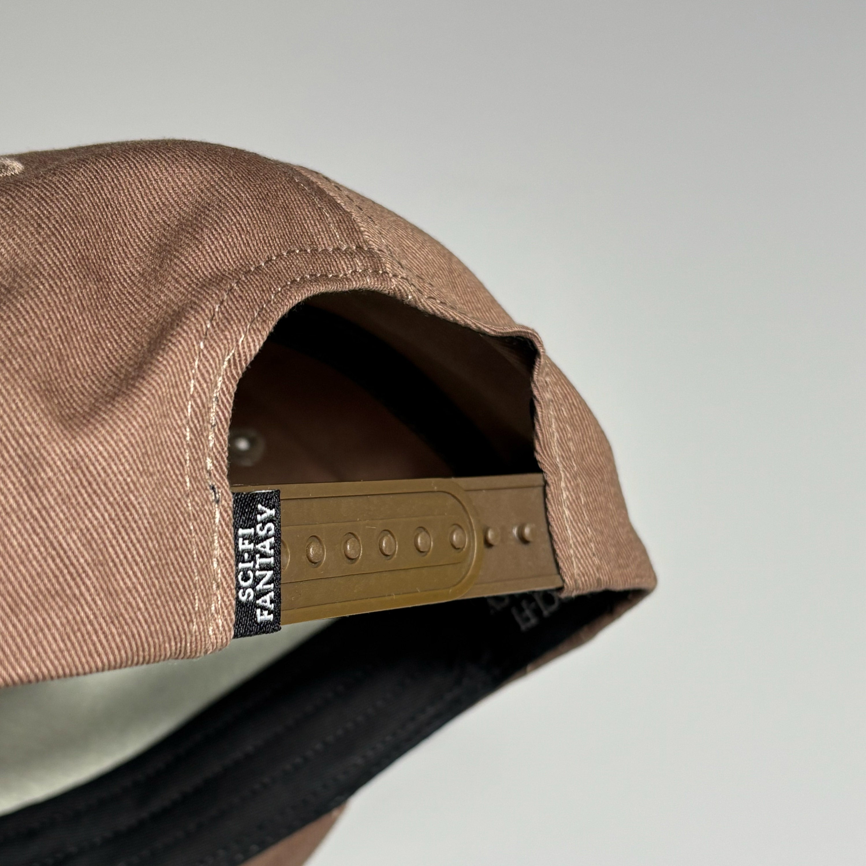 Back detail of snapback closure with sci-fi label.