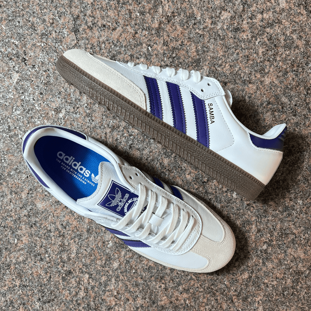 ADIDAS SKATEBOARDING SAMBA ADV SHOES IN WHITE LEATHER, TOE SUEDE, PURPLE STRIPES AND BROWN GUM SOLE DISPLAYED ON GRANITE