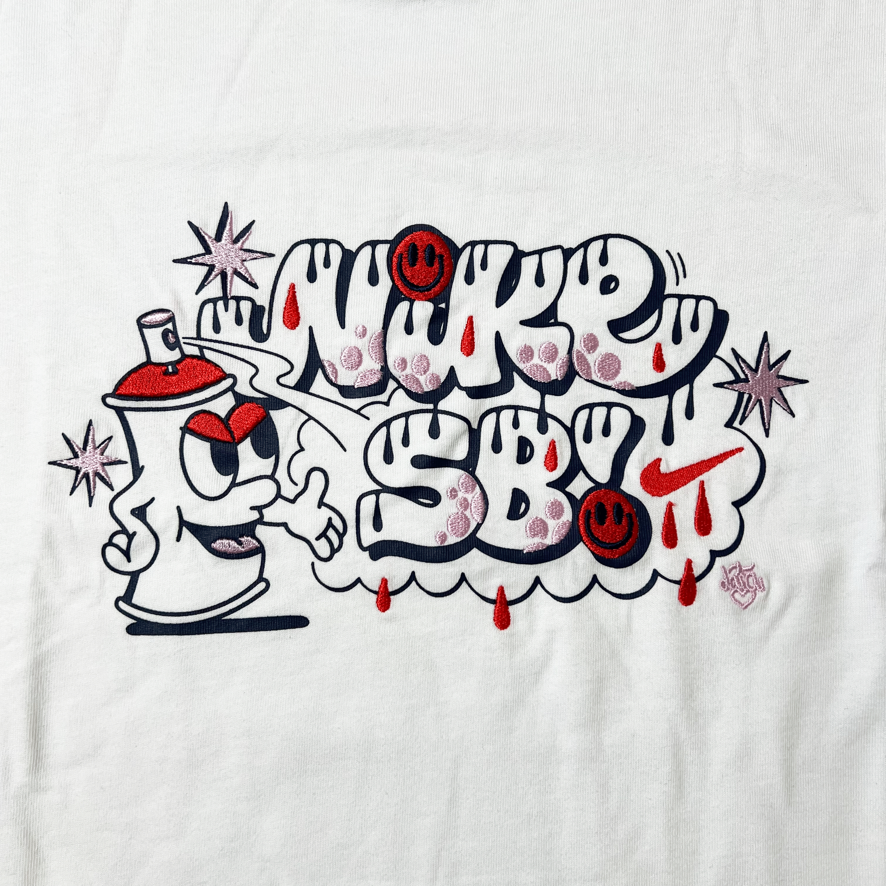 DETAILED VIEW OF THE NIKE SB EMBROIDERED SPRAY CAN LOGO ON CHEST