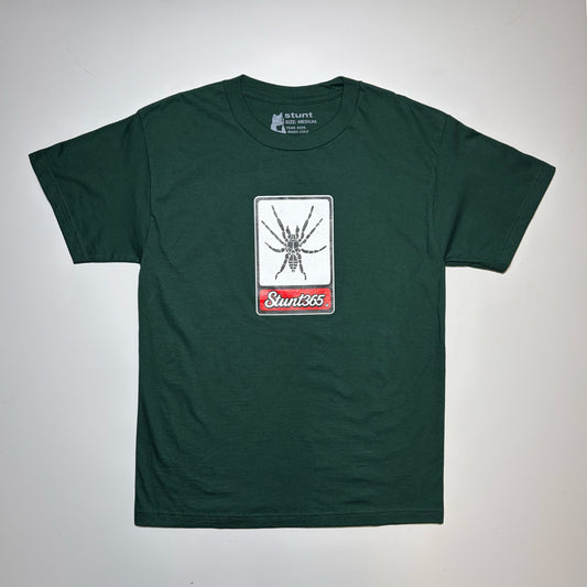 A dark green short-sleeve t-shirt laid flat on a light gray background. The center of the chest features a rectangular graphic with a black spider on a white background and a red banner below with the text 'Sunt365'.