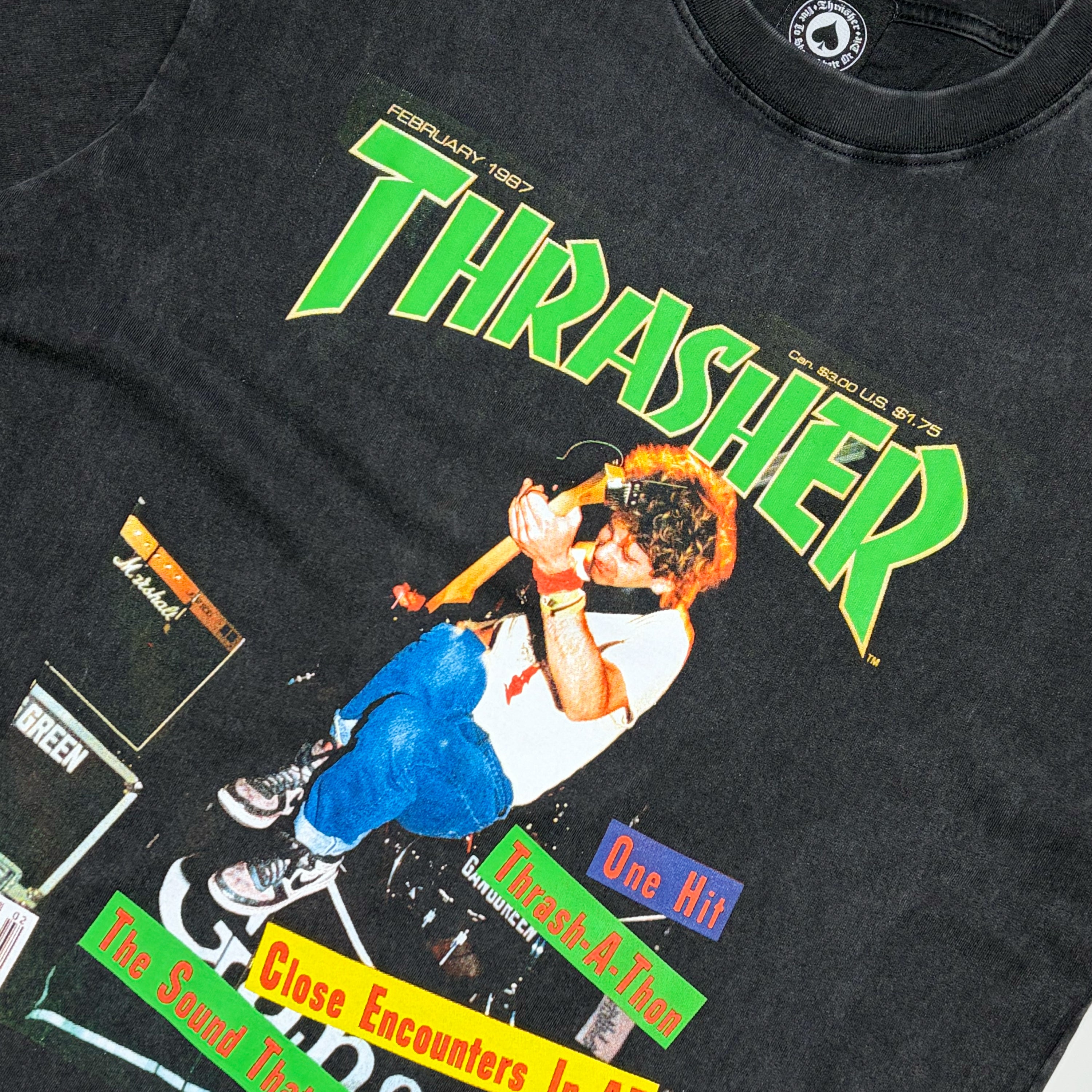 Close detail of vintage black Thrasher Magazine with guitar player jumping art on chest.
