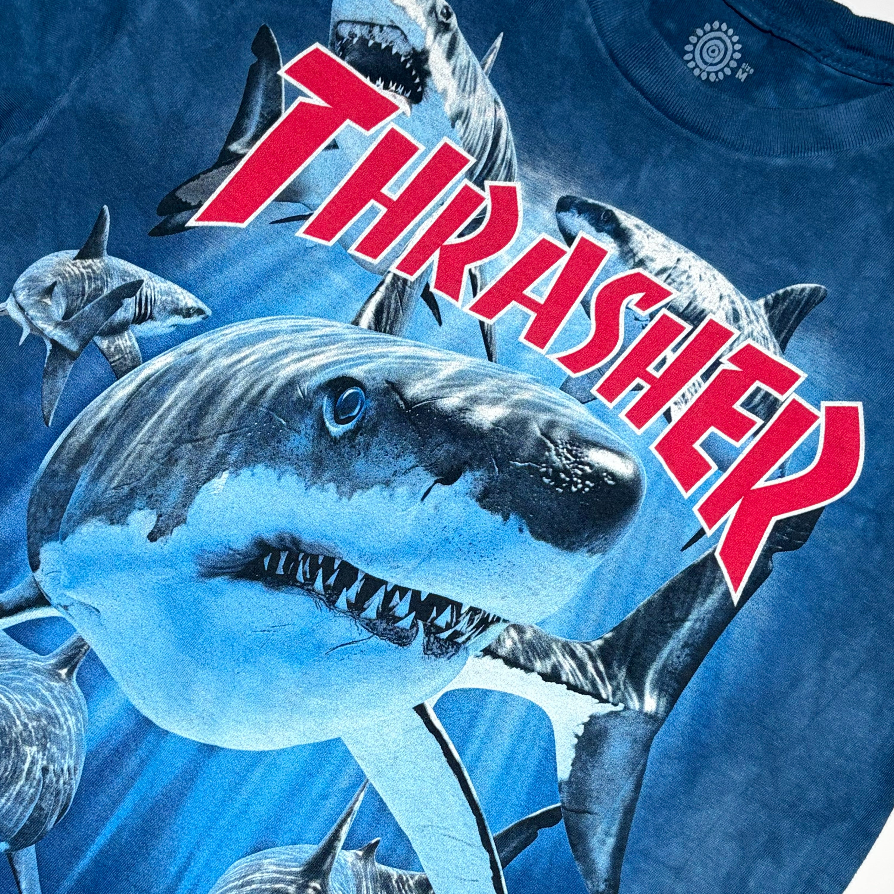 Close detail of Thrasher shark art printed on chest.