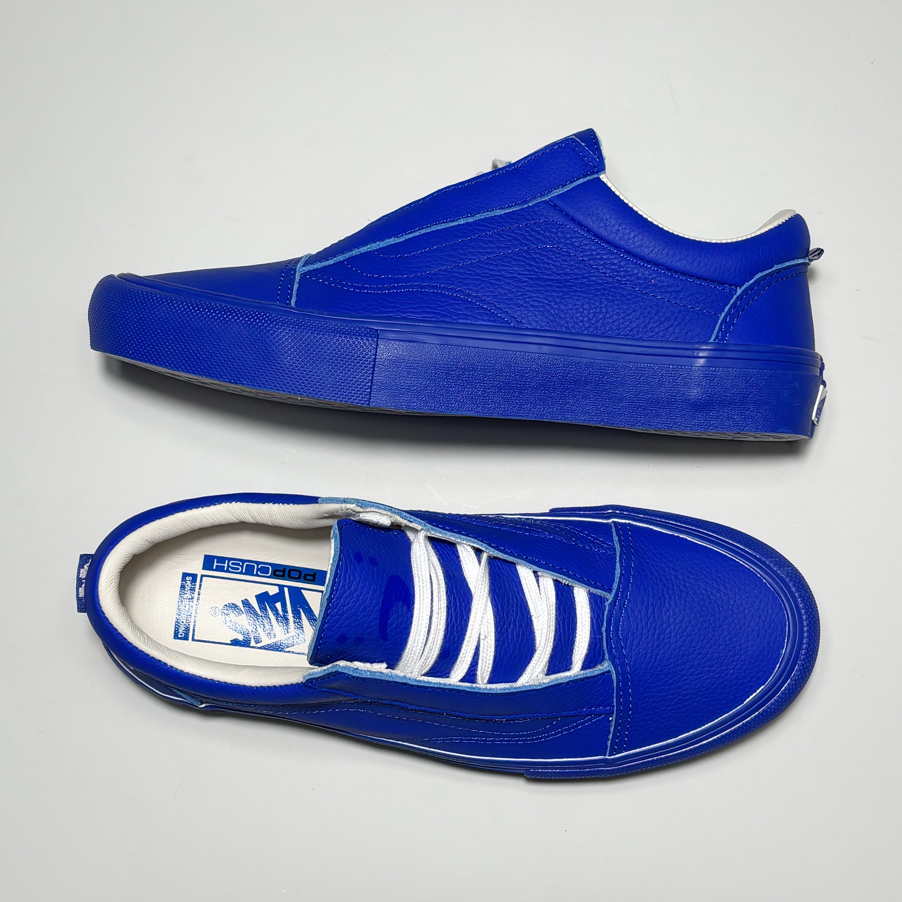 Toe down view with side profile. Custom 2 riser branding printed on tongue with white laces. 