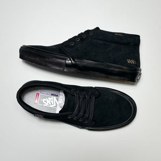 A pair of black Vans Skate Chukka suede low-top sneakers, one shown from the side profile and the other from the top-down view, on a light gray background. Part of the Atiba Jefferson collection.