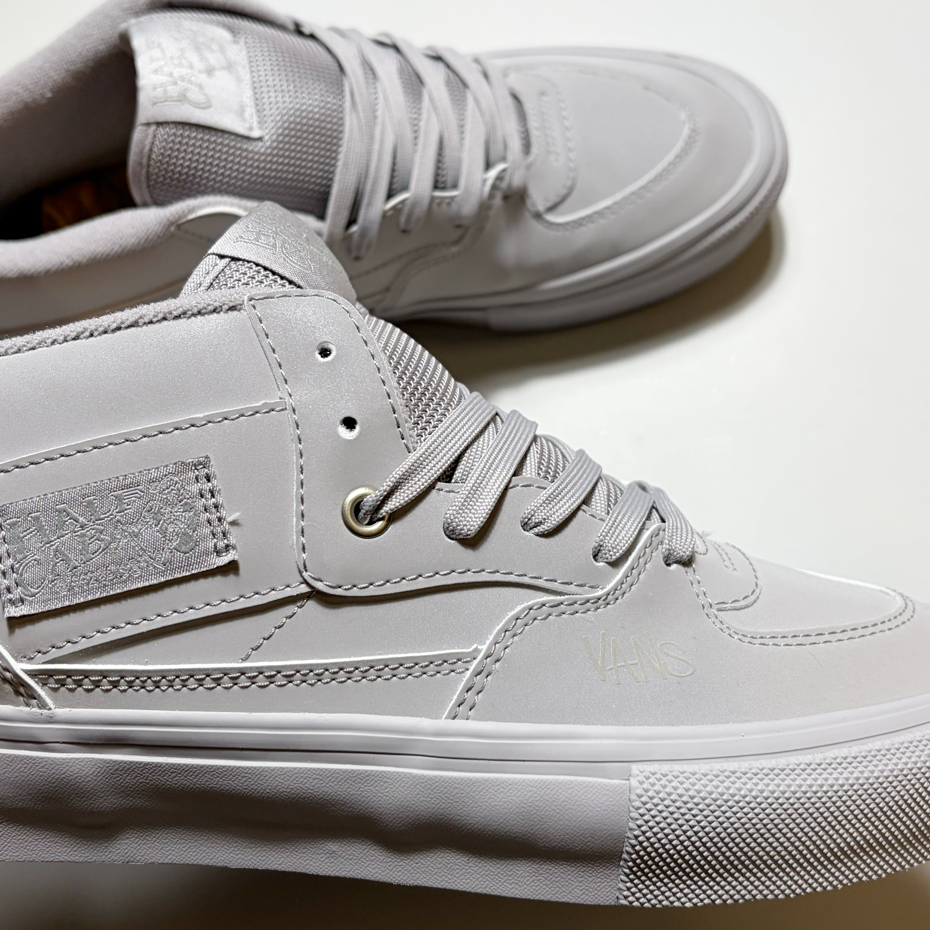 A pair of light gray high-top Vans Skate Half Cab sneakers shown in a close-up studio shot on a white background. Custom Atiba Jefferson color way.