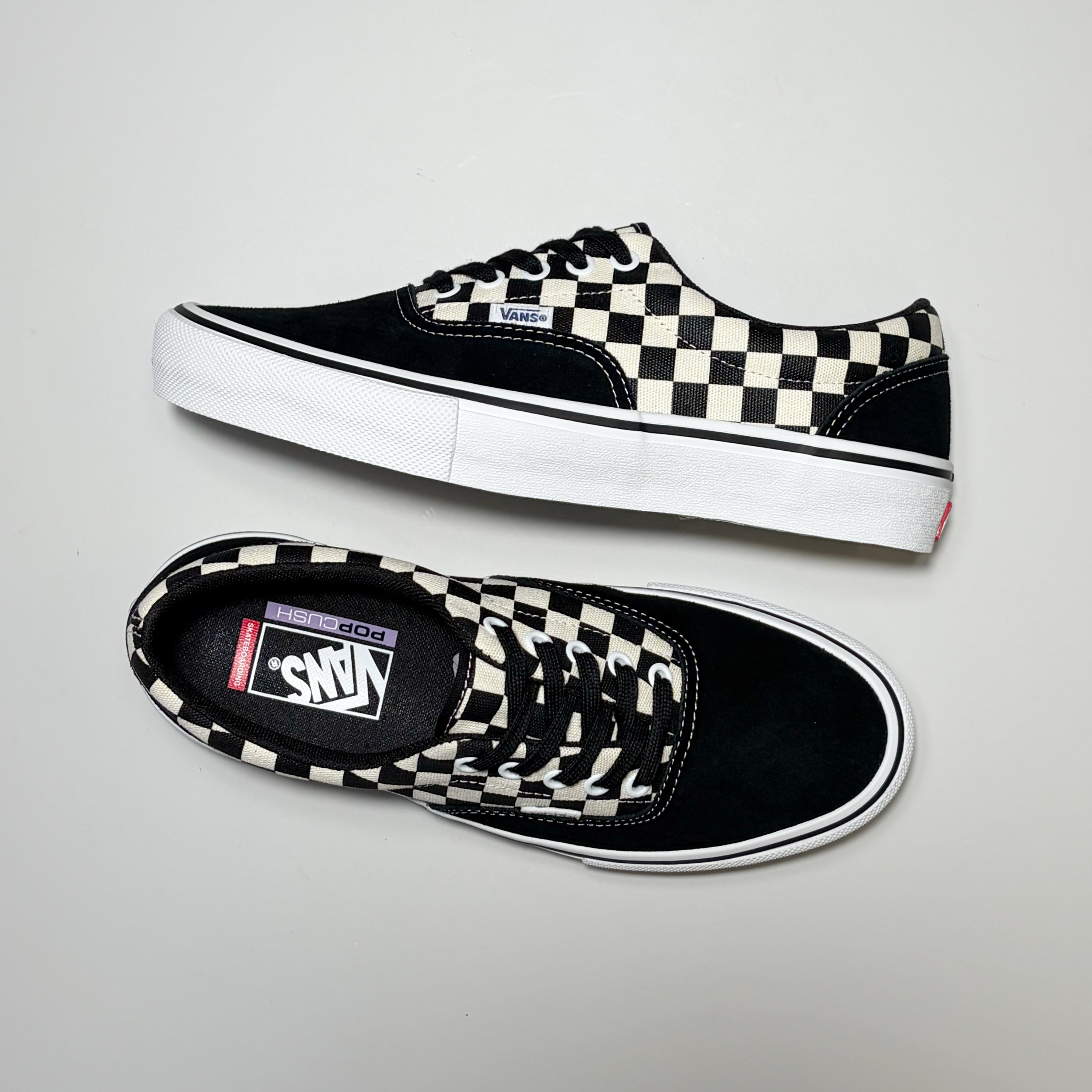 A pair of Vans Skate Era sneakers in black and white checkerboard canvas, shown from both side and top-down angles on a light gray background.