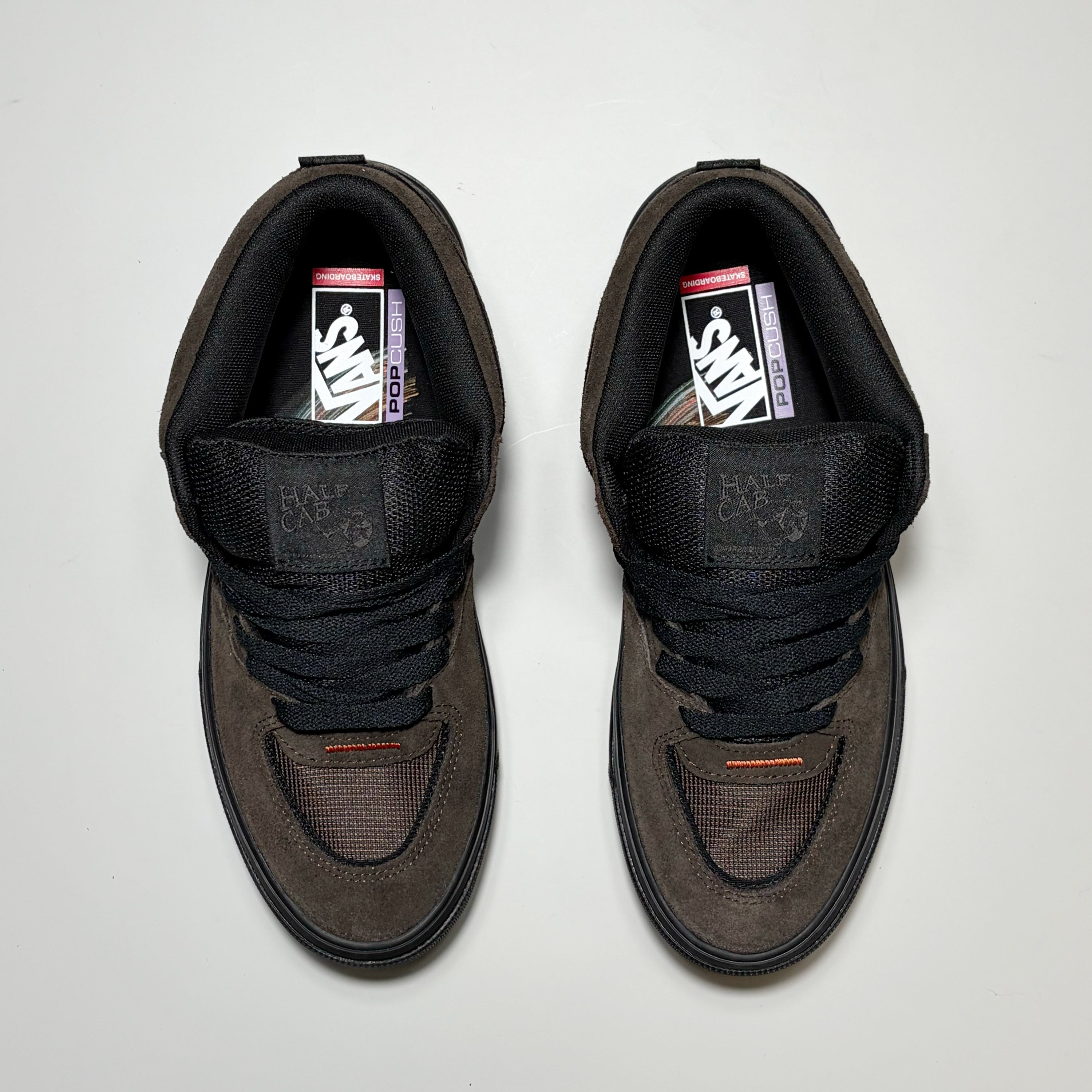 A pair of Vans Skate Half Cab Wafflecup Dick Rizzo sneakers in dark brown suede and black mesh, viewed from directly above on a light gray background