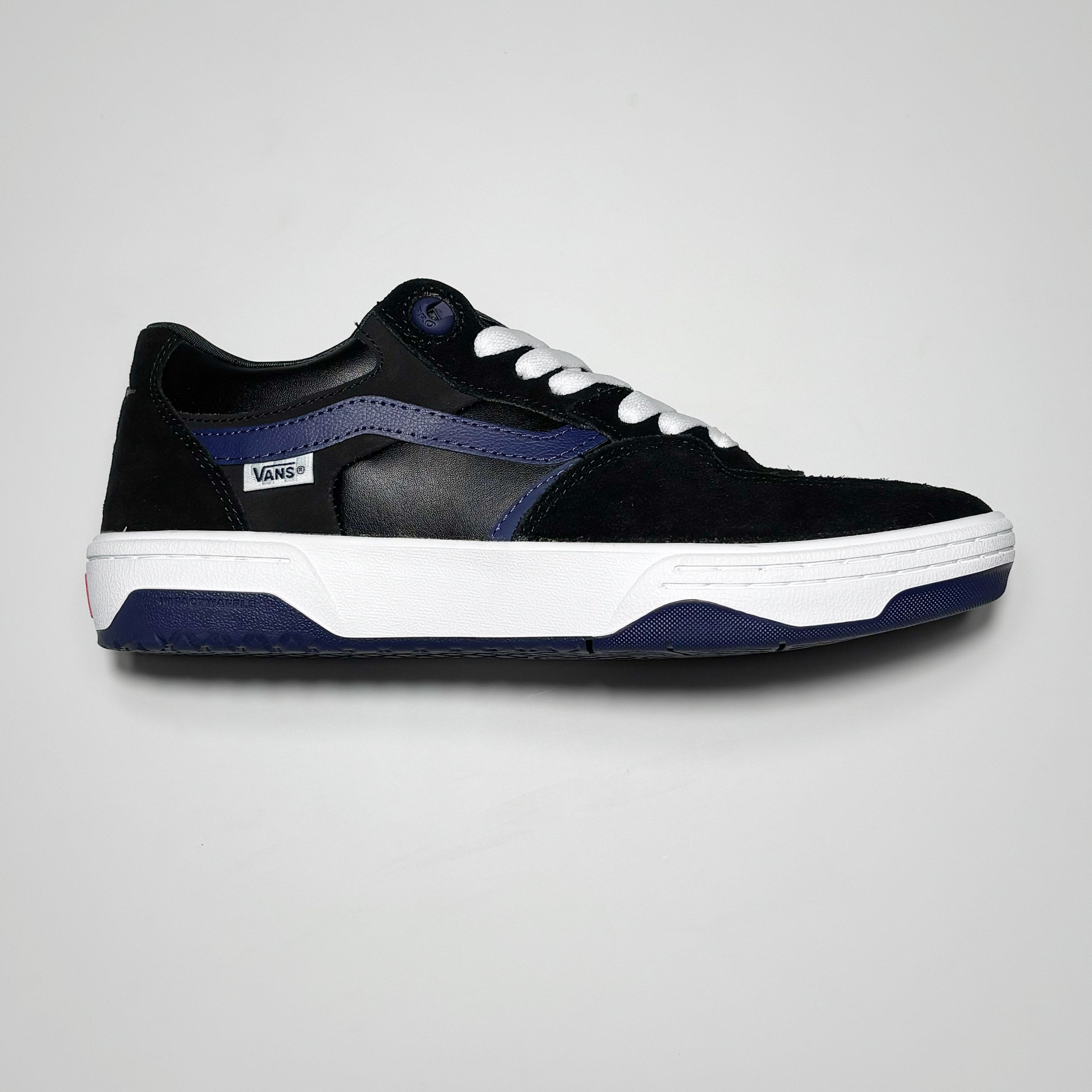 Side image of right shoe. Black suede with purple stripe and outsole.