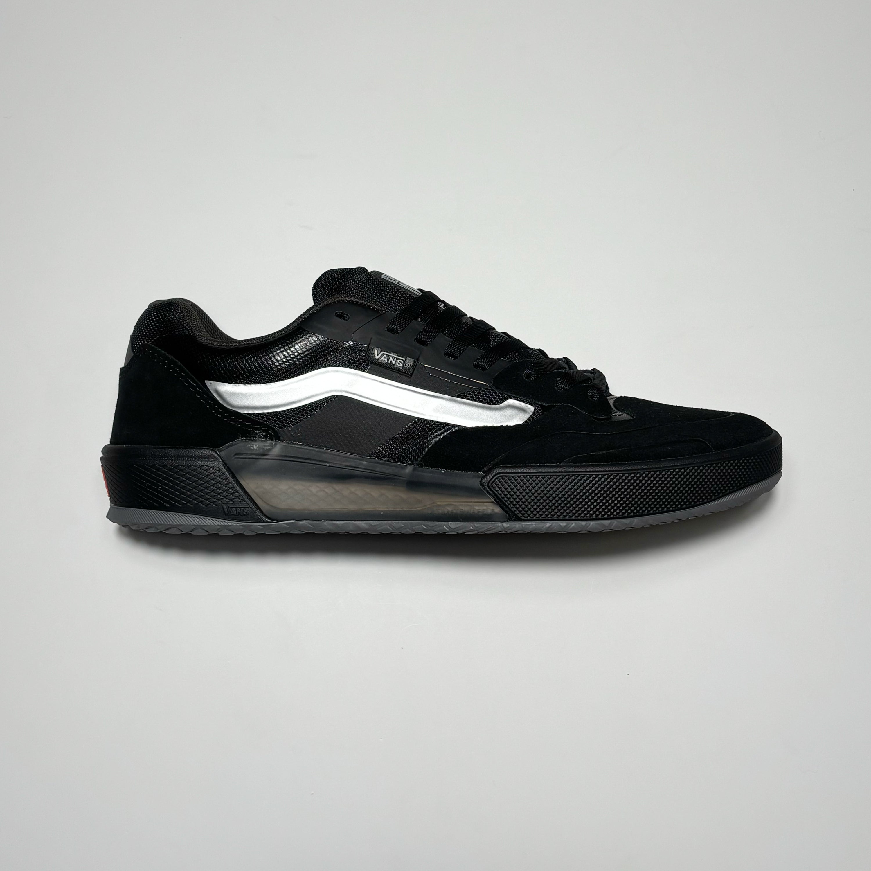 Side image of right shoe. Black suede with silver vans stripe.