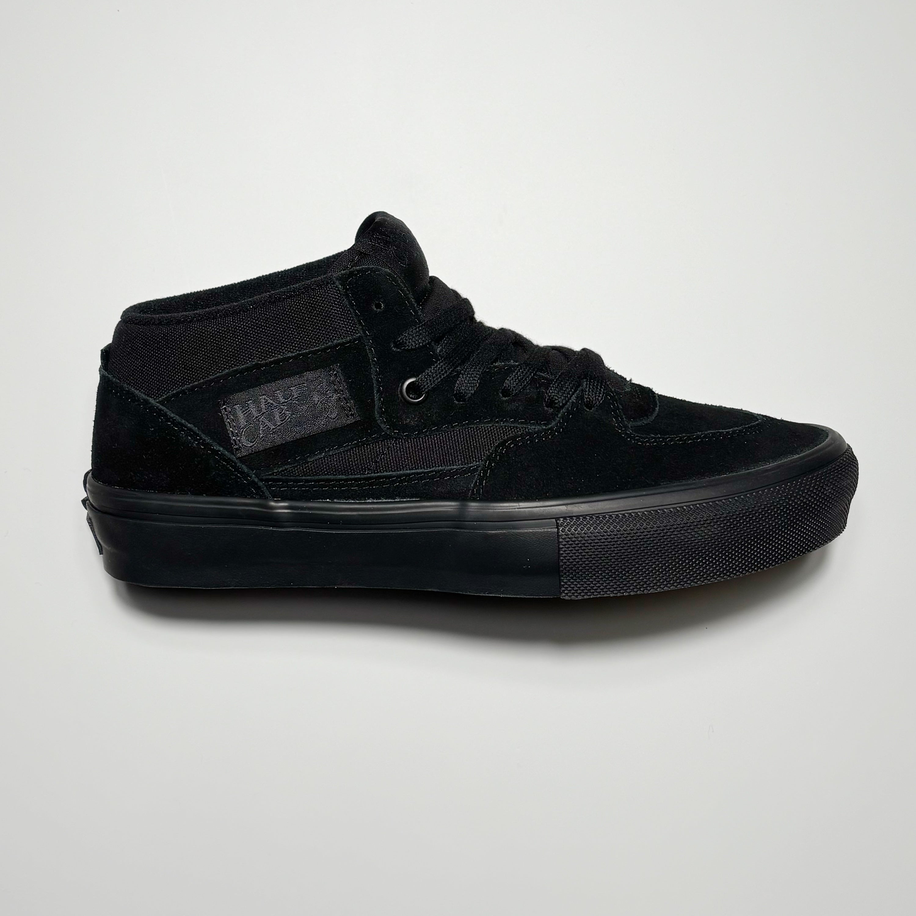 Side image of right shoe. Black suede with black mid panels and outsole.