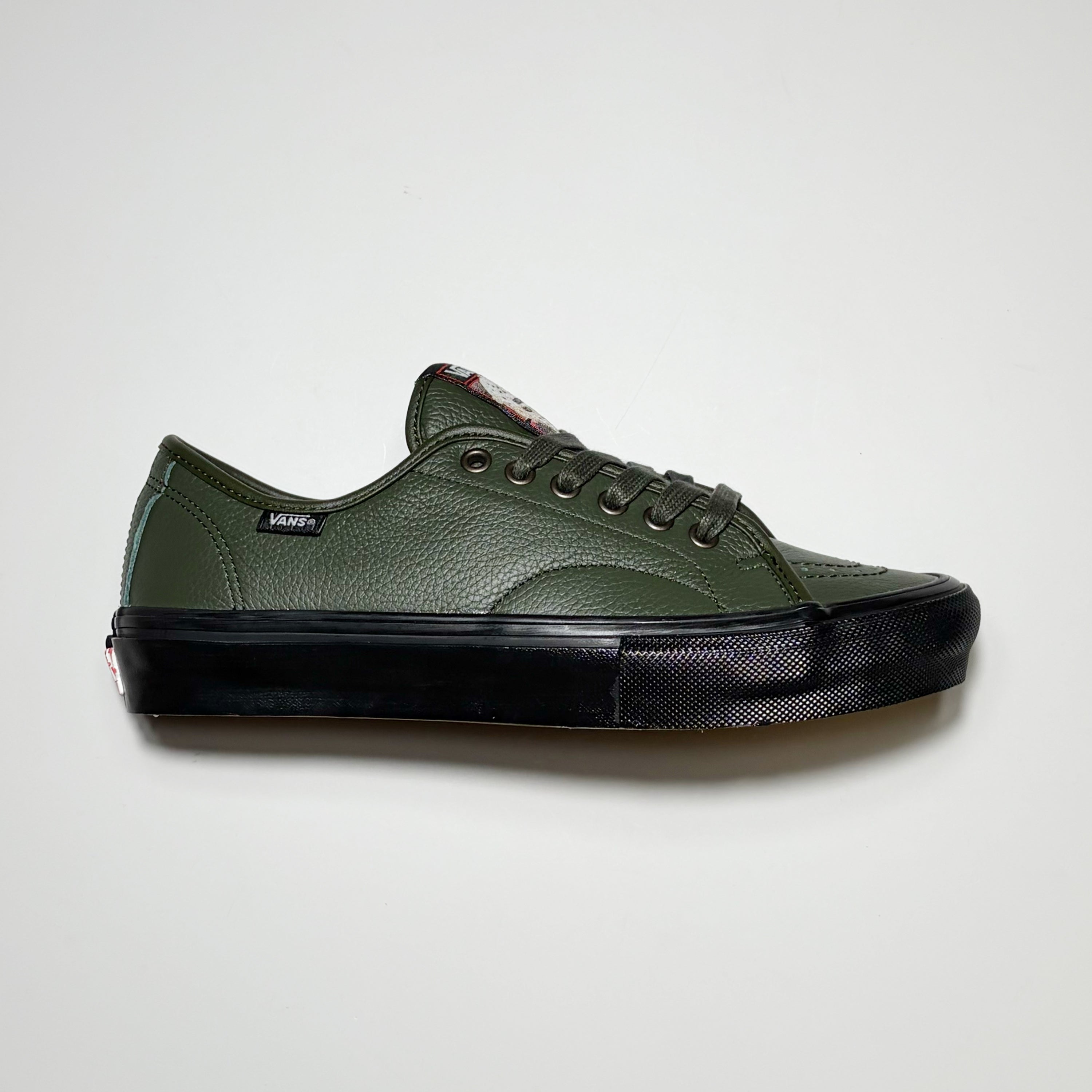 Right side image of shoe. Vans VCU AVE Classic in green leather with black midsole. Vans woven label on heel. VCU Limited Project Footwear