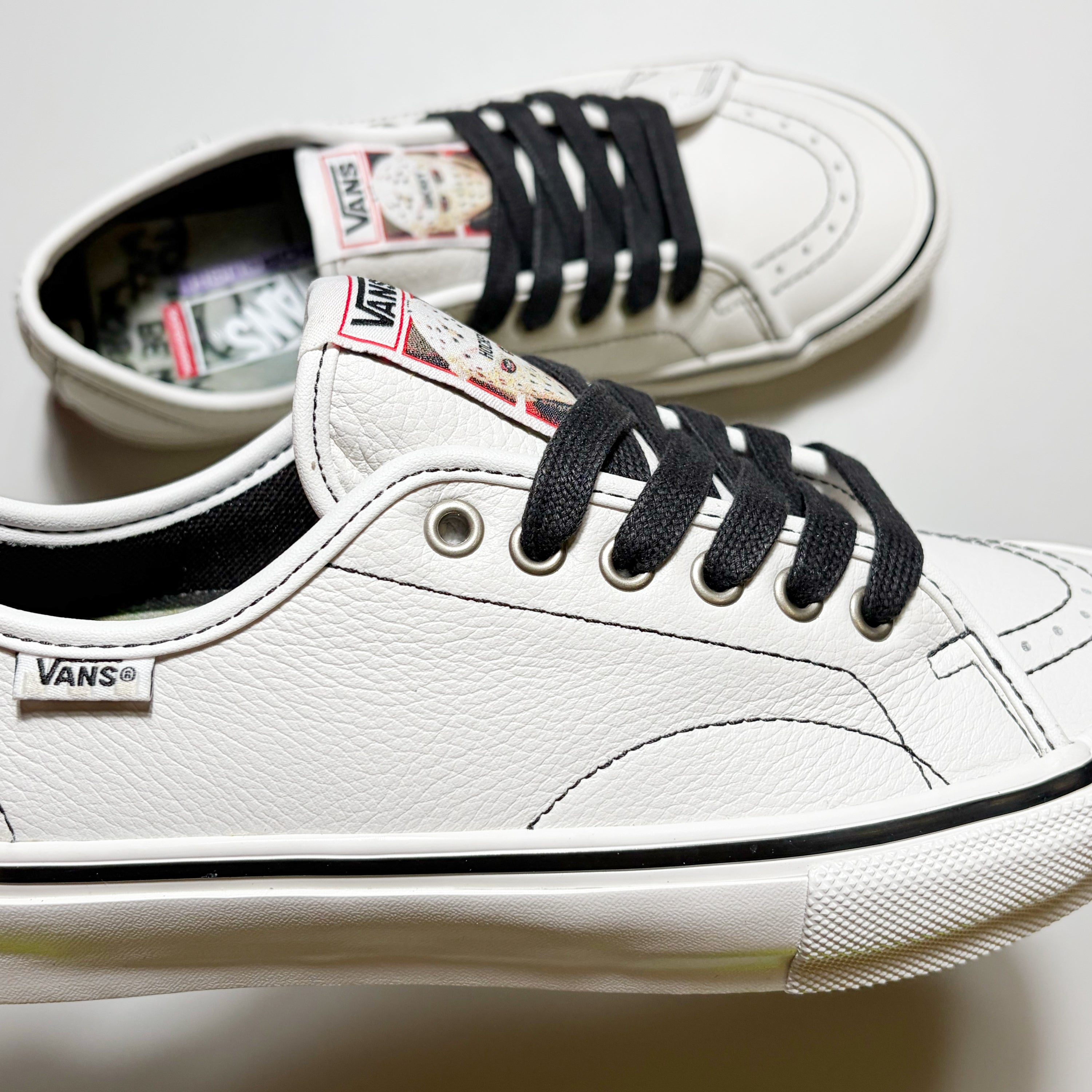 Close detail of Vans VCU AVE Classic shoe. Premium white leather with black contrast stitch and laces.