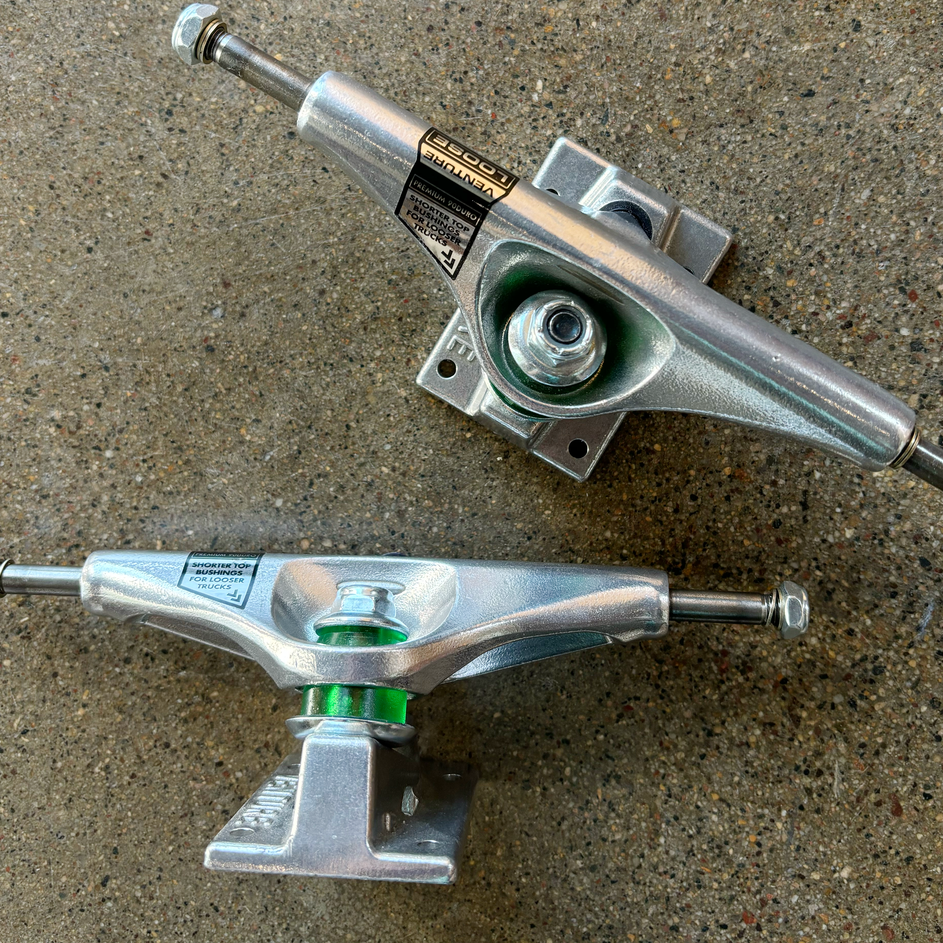 Close details of trucks, green bushings with polished silver baseplate & hanger.