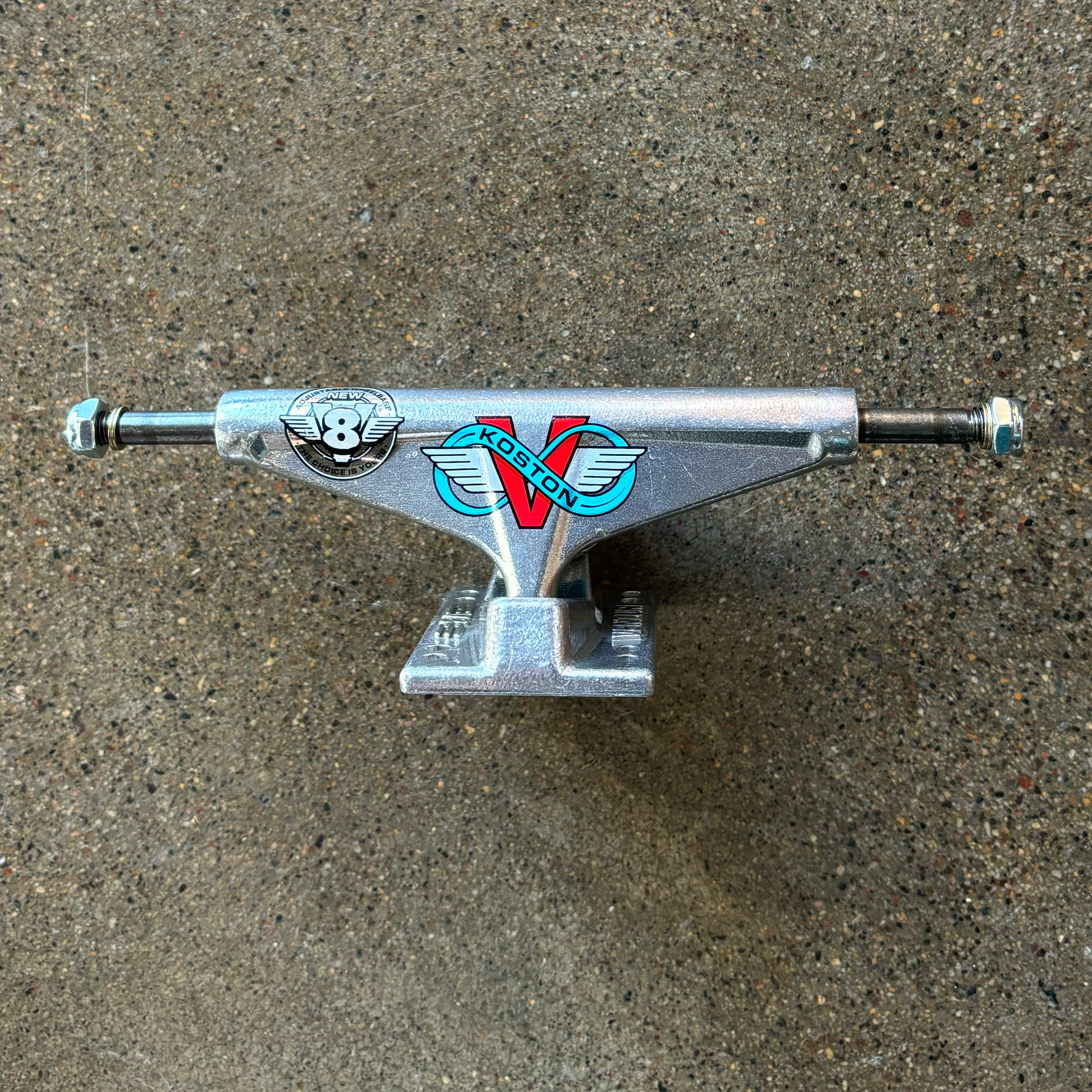 Full image of truck. 
Polished silver with Koston V8 art on hanger.