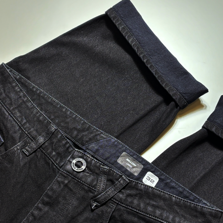 Close detail black of black denim with cuff.