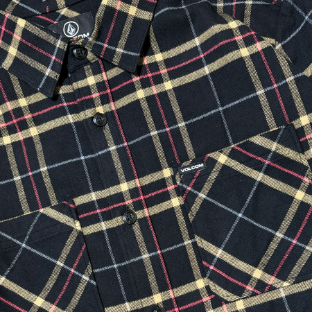 Close detail of black, yellow and red plaid fabric. Volcom woven label on pocket.